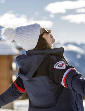 femme en tenue de ski regardant le ciel